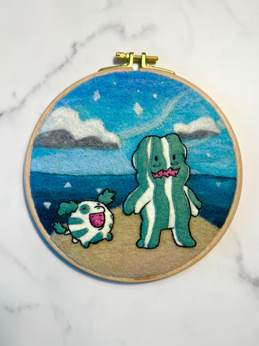 Embroidery hoop with watermelon steven and watermelon dog from Steven universe embroidered over a needle felted background.